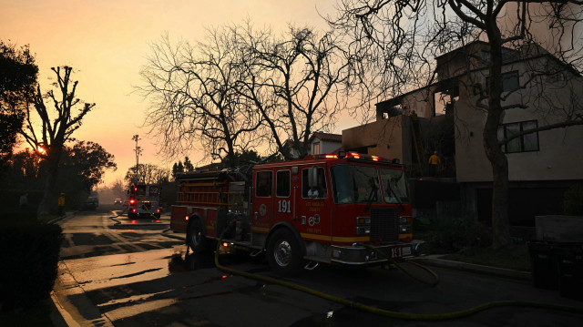 Des pompiers utilisent un tuyau d'arrosage pour éteindre les braises dans une maison lors de l'incendie de Palisades à Pacific Palisades, un quartier de Los Angeles, Californie, le 9 janvier 2025.