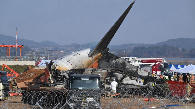 Des pompiers et du personnel de secours travaillent près de l'épave d'un Boeing 737-800 de Jeju Air après l'accident et l'incendie de l'aéroport international de Muan, dans la province de South Jeolla, à quelque 288 kilomètres au sud-ouest de Séoul, le 29 décembre 2024.