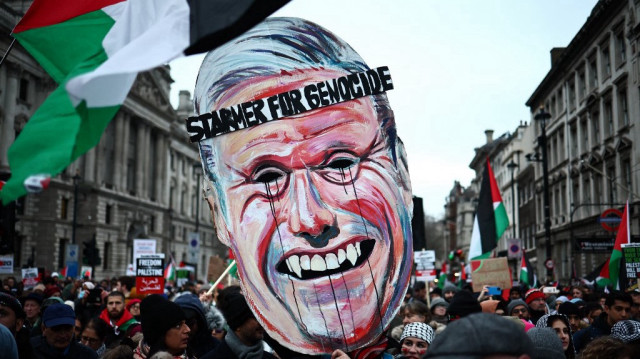 Des manifestants pro-palestiniens brandissent un gigantesque masque du leader du parti travailliste britannique, Keir Starmer, lors d'une marche nationale pour la Palestine dans le centre de Londres, le 13 janvier 2024.