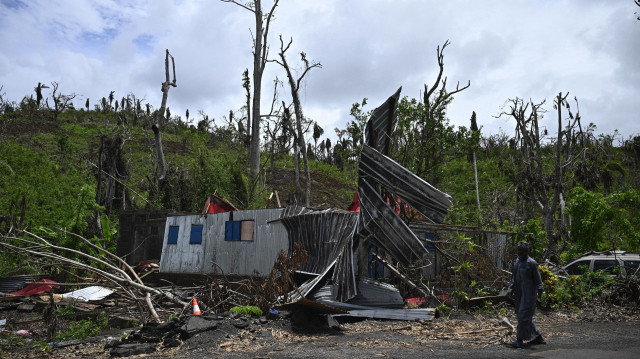 Un homme marche devant une maison détruite par le cyclone Chido dans le village de Bandraboua, sur le territoire français de Mayotte, dans l'océan Indien, le 4 janvier 2025. Le cyclone le plus dévastateur à frapper Mayotte depuis 90 ans a causé des dégâts colossaux le 14 décembre 2024, dans le département le plus pauvre de France.