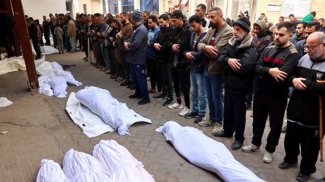 Des personnes en deuil prient sur les corps de leurs proches tués lors de frappes israéliennes dans la ville de Gaza la nuit précédente, à l'hôpital arabe Al-Ahli, également connu sous le nom d'hôpital baptiste, le 16 janvier 2025, alors que la guerre entre Israël et le mouvement palestinien Hamas se poursuit.