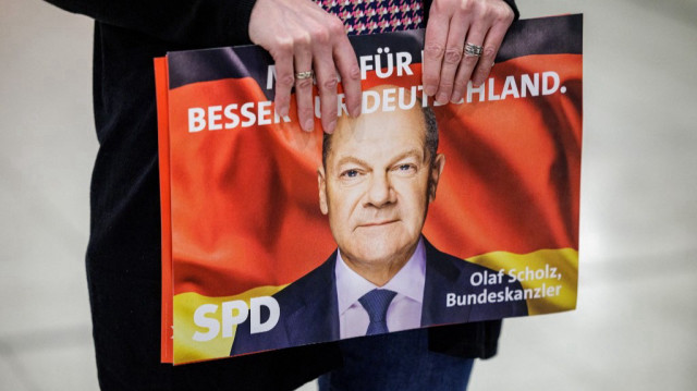 Un participant tient une affiche de campagne montrant un portrait du chancelier allemand Olaf Scholz lors du lancement de la campagne électorale du parti social-démocrate allemand SPD à Wolfsburg, Allemagne, le 17 janvier 2025.