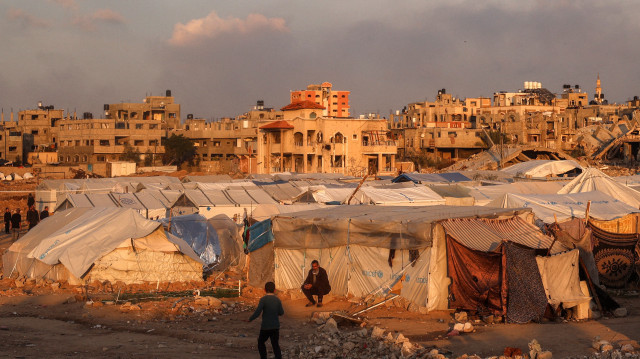 Un homme est assis à l'extérieur d'une tente dans un camp pour personnes déplacées par le conflit à Bureij, dans le centre de la bande de Gaza, le 17 janvier 2025, suite à l'annonce d'une trêve dans le cadre de la guerre entre Israël et le Hamas.