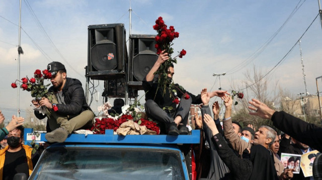 Des Iraniens distribuent des roses rouges pour célébrer l'accord de cessez-le-feu à Gaza lors d'un rassemblement après la prière du vendredi midi à Téhéran, le 17 janvier 2025.