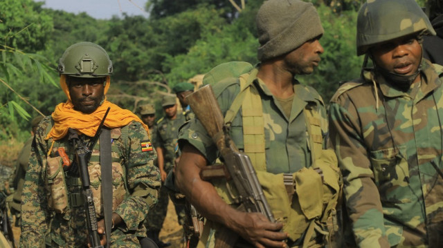 Des soldats des FARDC (Forces armées de la République démocratique du Congo) (à droite) et des Forces de défense du peuple ougandais (UPDF) patrouillent à Lesie, le 10 décembre 2021, avant une offensive attendue contre les célèbres rebelles de l'ADF de la région.