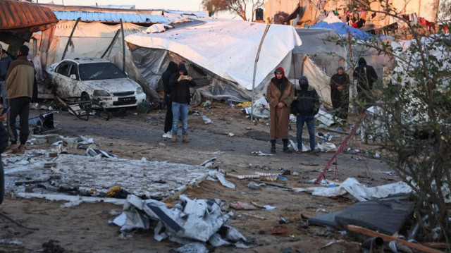 Des Palestiniens déplacés marchent parmi les débris de tentes dispersés après une frappe israélienne nocturne sur Khan Younès, dans le sud de la Bande de Gaza, le 02 janvier 2025.