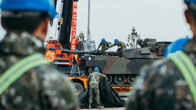 Des soldats en train de fixer un char de combat M1A2 Abrams de fabrication américaine sur une remorque dans un centre d'entraînement blindé de l'armée dans le comté de Hsinchu, à Hsinchu, le 16 décembre 2024.