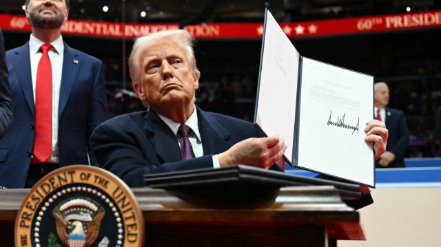 Le président américain Donald Trump tient une lettre adressée à l'ONU indiquant le retrait des États-Unis de l'accord de Paris, à la Capital One Arena, à Washington, DC, le 20 janvier 2025.