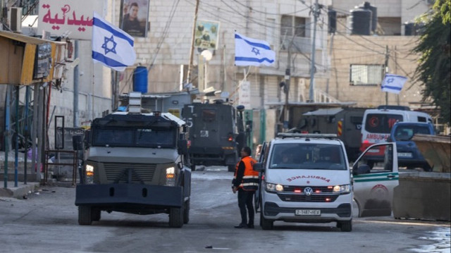 L'armée d'occupation, à bord de véhicules blindés, a stoppé une ambulance palestinienne pour la fouiller alors qu'elle bloquait une route pendant un raid à Jénine, en Palestine occupée, le 21 janvier 2025.