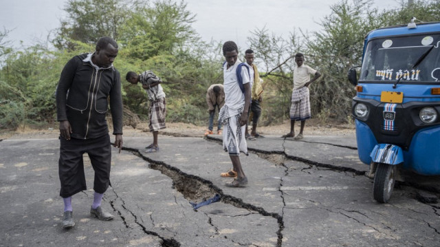 Des habitants évaluent les dégâts sur une route touchée par de multiples tremblements de terre près de la ville de Kabanna, le 12 janvier 2025.