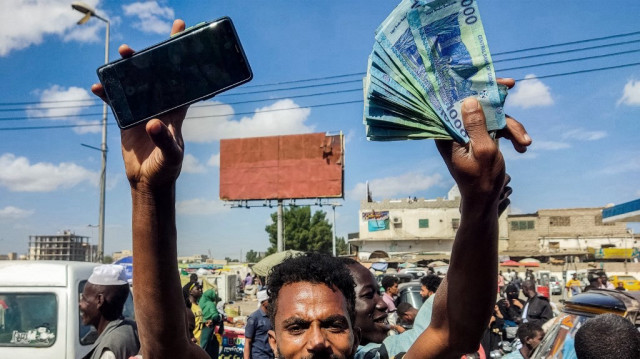 Des personnes manifestent pour demander au gouvernement soudanais soutenu par l'armée de repousser la date limite d'échange des billets de banque en livres soudanaises après que les autorités aient changé deux des billets en circulation, invalidant les anciens, dans la ville de Port Soudan, au nord-est de la mer Rouge, le 31 décembre 2024.