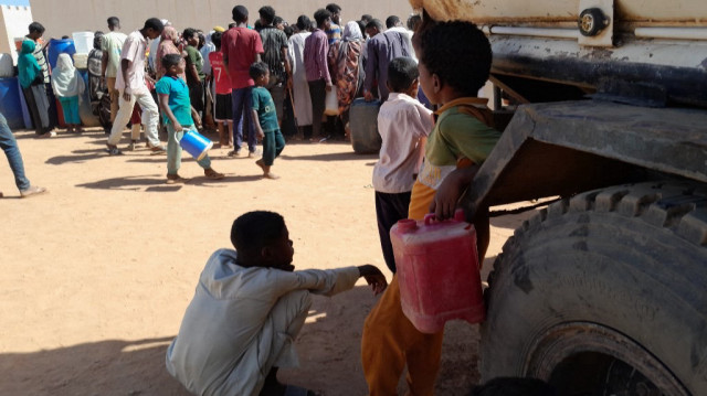 Des personnes font la queue pour obtenir de l'eau à Omdurman, la ville jumelle de la capitale soudanaise, pendant les batailles entre les forces militaires soudanaises et les forces paramilitaires de soutien rapide (RSF), le 17 janvier 2025.