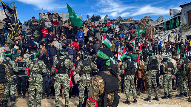 Des combattants du Hamas et des habitants se rassemblent sur une place avant de remettre quatre otages israéliens à la Croix-Rouge dans la ville de Gaza, le 25 janvier 2025. 