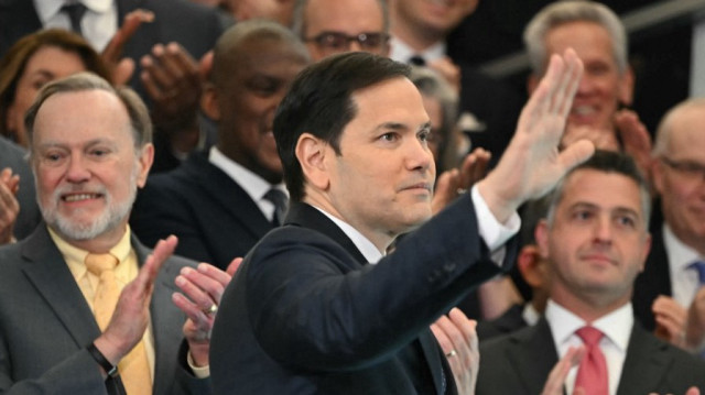 Le secrétaire d'État américain Marco Rubio salue les employés à son arrivée au département d'État à Washington, DC, le 21 janvier 2025.