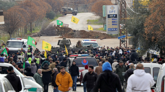 Une jeep militaire israélienne et des ambulances sont garées de part et d'autre d'une barricade de terre à Borj El Mlouk, le 26 janvier 2025, sur une route menant à Kfar Kila, dans le sud du Liban, où les habitants déplacés se sont rassemblés dans l'espoir de rentrer chez eux. Les troupes israéliennes ont tiré sur des habitants du Sud-Liban le 26 janvier, tuant deux personnes et en blessant 32 autres, selon les autorités sanitaires, alors que des centaines de personnes tentaient de rentrer chez elles à la date limite fixée pour le retrait des forces israéliennes de la région.