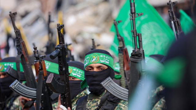 Des combattants du Hamas sécurisent une zone sur une place avant de remettre quatre otages israéliens à une équipe de la Croix-Rouge dans la ville de Gaza, le 25 janvier 2025. Quatre femmes otages israéliennes libérées sont rentrées chez elles en Israël le 25 janvier, mettant fin à plus de 15 mois de captivité après que des militants du Hamas les ont remises à la Croix-Rouge dans le cadre d'un accord de trêve dans la guerre de Gaza.