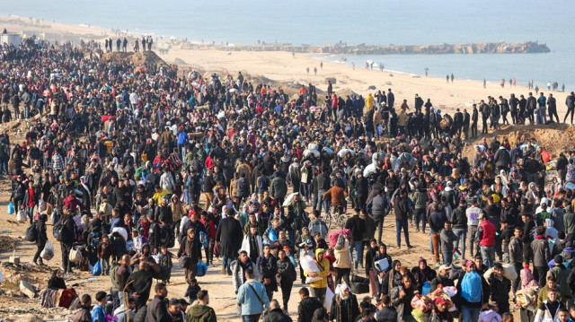 Des dizaines de milliers de Palestiniens, déplacés par les forces israéliennes, retournent dans leurs maisons par la rue Al-Rashid sur la bande côtière après l'accord de cessez-le-feu dans la ville de Gaza, le 27 janvier 2025.