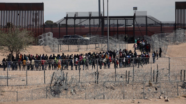 Des migrants attendant d'être transférés par la patrouille frontalière américaine après avoir traversé la rivière Bravo à El Paso, au Texas, vu depuis Ciudad Juarez, dans l'État de Chihuahua, au Mexique, le 18 avril 2024.