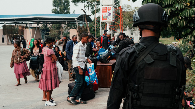 Le personnel non essentiel de la MONUSCO, ainsi que d'autres employés des Nations Unies et des agents consulaires, font inspecter leurs effets personnels par des agents de sécurité rwandais alors qu'ils attendent d'être évacués au poste frontière de Corniche à Gisenyi, le 27 janvier 2025.