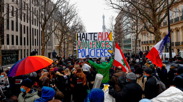 Un manifestant tient une pancarte sur laquelle on peut lire "Halte aux violences policières" lors d'une marche blanche en mémoire de Cédric Chouviat, à Paris, le 3 janvier 2021.