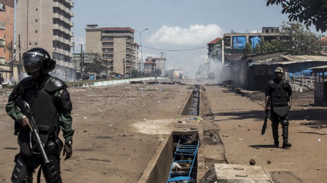 Des policiers font face à des manifestants qui continuent de jeter des pierres et de bloquer des routes lors de manifestations de masse après la publication des résultats préliminaires à Conakry, le 23 octobre 2020.