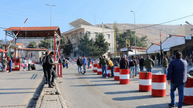 Des personnes attendent à l'entrée du poste frontière d'Al-Masnaa, à l'est du Liban, avec la Syrie, le 3 janvier 2025, après que la Syrie a imposé de nouvelles restrictions à l'entrée des citoyens libanais.