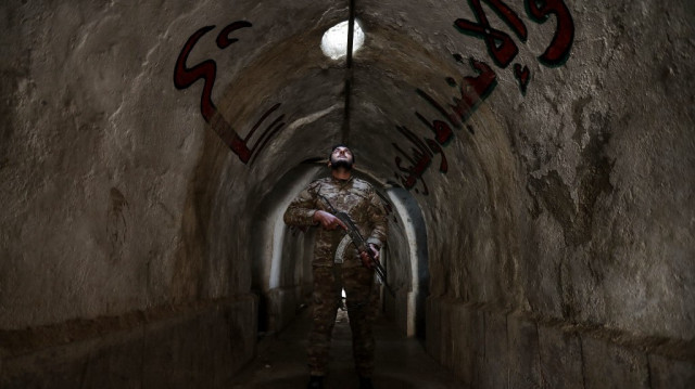 Un combattant affilié à la nouvelle administration syrienne se tient dans un tunnel, à l'intérieur de la base abandonnée de la Garde républicaine syrienne (SRG) près de Damas, le 4 janvier 2025.