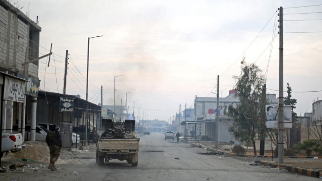 Des combattants affiliés à la faction de l'Armée nationale syrienne soutenue par la Türkiye patrouillent sur une route dans le nord-est de la région de Manbij, dans la province d'Alep, le 4 janvier 2025.