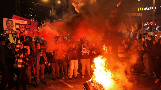 Des manifestants brûlent des pancartes lors d'une manifestation appelant à la libération des otages détenus à Gaza par des militants palestiniens depuis les attaques du 7 octobre, devant le siège du ministère de la Défense à Tel-Aviv, le 4 janvier 2025. 