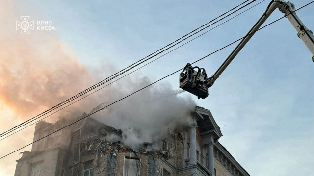 Cette photo prise et diffusée par le service d'urgence de l'État ukrainien le 1er janvier 2025 montre des pompiers éteignant un incendie dans un immeuble résidentiel à la suite d'une attaque de drones russes à Kiev, dans le cadre de l'invasion russe de l'Ukraine.