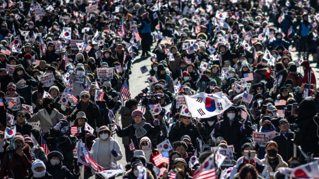 Des personnes agitent des drapeaux américains et sud-coréens lors d'un rassemblement de soutien au président sud-coréen Yoon Suk Yeol, dans le quartier de Gwanghwamun à Séoul, le 4 janvier 2025.