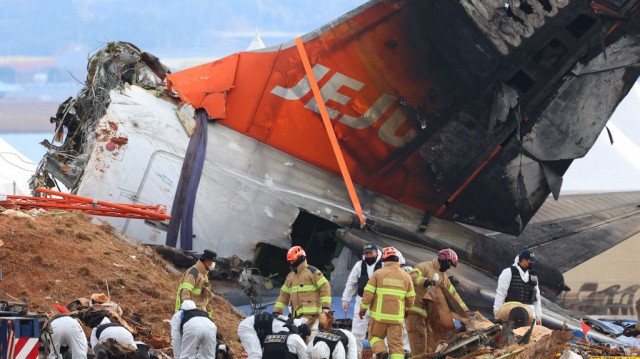 Des enquêteurs et du personnel d'intervention d'urgence travaillent sur le site où un Boeing 737-800 de Jeju Air s'est écrasé et a pris feu à l'aéroport international de Muan, à quelque 288 kilomètres au sud-ouest de Séoul, le 4 janvier 2025.