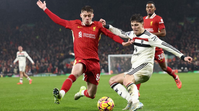 Le défenseur nord-irlandais de Liverpool, le n°84 Conor Bradley, lutte avec le milieu de terrain argentin de Manchester United, le n°17 Alejandro Garnacho, lors du match de football de la Premier League anglaise entre Liverpool et Manchester United à Anfield, le 5 janvier 2025.