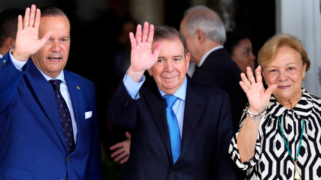 Edmundo Gonzalez Urrutia (centre), sa femme Mercedes Lopez et le ministre des Affaires étrangères du Panama, Javier Martinez Acha, saluent à leur arrivée pour une réunion avec le président du Panama Jose Raul Mulino au palais présidentiel de Panama City le 8 janvier 2025. 