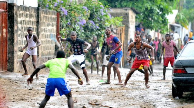 Des membres du Secteur du Rail Aunts "Kuluna" (gang d'enfants des rues) se battent avec des membres du Likonzi Kuluna (à l'arrière-plan) le 16 novembre 2012 dans une rue de Lingwala, au nord de Kinshasa.