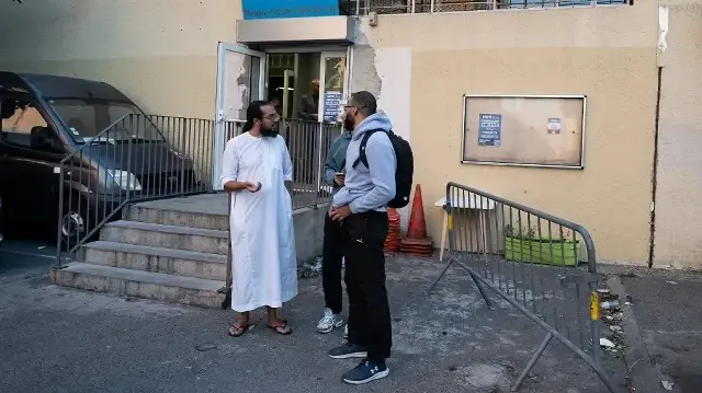 L'imam de la mosquée des Bleuets, l'imam Ismail (à gauche), s'entretient avec des habitants après sa conférence de presse, à Marseille, dans le sud de la France, le 9 septembre 2024, après que le préfet de police des Bouches-du-Rhône a informé la mosquée des Bleuets de son intention de la fermer, estimant que des "propos légitimant la violence" y étaient tenus depuis des années.