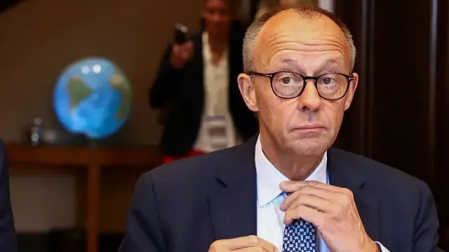 Le chancelier allemand Friedrich Merz ajuste sa cravate avant une séance du cabinet fédéral allemand, lors d’une réunion de deux jours à la Villa Borsig, maison d’hôtes du ministère allemand des Affaires étrangères, à Berlin, le 1er octobre 2025.