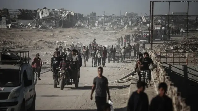 Des centaines de Palestiniens continuent de revenir du sud vers le nord, transportant leurs biens le long de la rue Salah al-Din, qui relie les parties nord et sud de l'enclave, au deuxième jour du cessez-le-feu dans la bande de Gaza, le 11 octobre 2025.