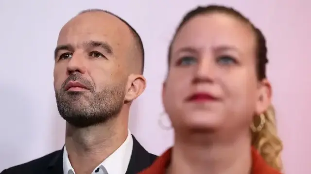 Manuel Bompard, député de La France Insoumise - Nouveau Front Populaire (au fond à gauche), debout derrière le président de La France Insoumise - Nouveau Front Populaire, Mathilde Panot (à droite, au premier plan), réagit lors d'une conférence de presse du fondateur du parti de gauche français La France Insoumise (LFI), Jean-Luc Mélenchon (absent), au siège de LFI, à Paris, le 10 octobre 2025.