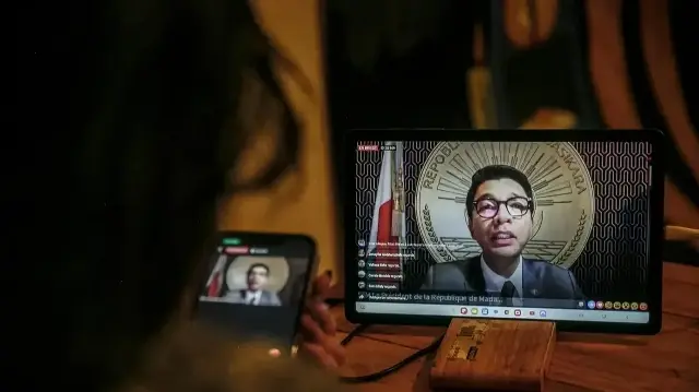 Une habitante d'Antananarivo regarde le discours du président malgache Andry Rajoelina à la nation via la page Facebook officielle de la présidence de Madagascar, depuis son domicile à Antananarivo, le 13 octobre 2025. Le président malgache Andry Rajoelina, en proie à des difficultés, a déclaré le 13 octobre 2025 qu'il se trouvait dans un "lieu sûr" après avoir été victime d'une tentative d'assassinat.