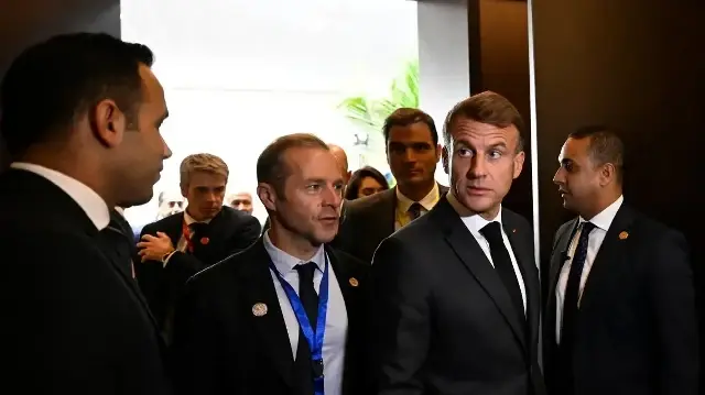 Le président français Emmanuel Macron (2e à droite) entre dans une salle lors d'un sommet sur Gaza à Charm el-Cheikh, le 13 octobre 2025.