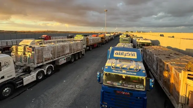 Des camions chargés d'aide humanitaire sont stationnés du côté égyptien du poste-frontière de Rafah, attendant d'accéder à la bande de Gaza, le 12 octobre 2025.