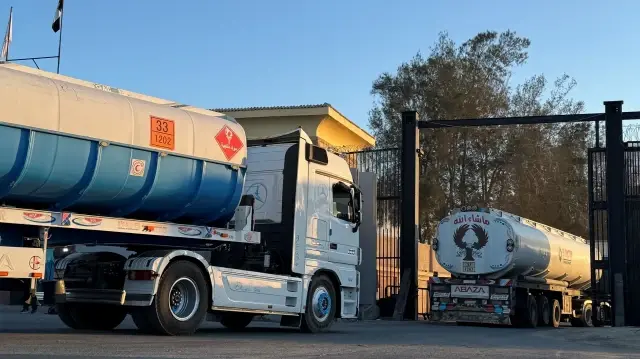 Des camions chargés de carburant traversent la frontière égyptienne pour entrer à Rafah, dans le sud de la bande de Gaza, tôt le matin du 15 octobre 2025, après qu'Israël a annoncé qu'il autoriserait la réouverture du passage pour l'aide humanitaire.