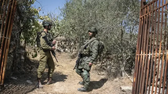 Des soldats israéliens bloquent l'accès à un oliveraie palestinienne près de la colonie israélienne d'Elazar, au sud de Bethléem, en Palestine occupée, le 17 octobre 2025.