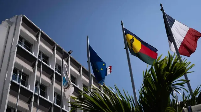 Cette photographie montre un drapeau kanak (2e à droite) à côté du drapeau français (à droite) et du drapeau européen (2e à gauche) devant la mairie de Nouméa, en Nouvelle-Calédonie, territoire français du Pacifique, le 23 septembre 2024.