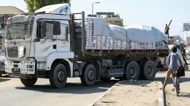 Des camions transportant l'aide fournie par le Programme alimentaire mondial (PAM) circulent sur une route à Deir el-Balah, dans la bande de Gaza, le 16 octobre 2025, dans le cadre d'un cessez-le-feu négocié par les États-Unis et d'un échange d'otages entre Israël et les factions palestiniennes dans le territoire assiégé.
