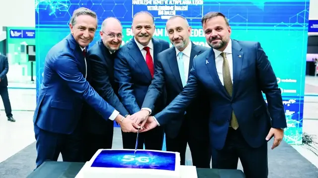 İhale sonrası Ulaştırma ve Altyapı Bakan Yardımcısı Ömer Fatih Sayan (ortada), BTK ve İhale Komisyonu Başkanı Ömer Abdullah Karagözoğlu (sol 2), Türk Telekom Üst Yöneticisi (CEO) Ümit Önal (sağ 2), Turkcell Genel Müdürü Ali Taha Koç (sağda) ve Vodafone Türkiye Üst Yöneticisi (CEO) Engin Aksoy (solda) üzerinde "5G" yazılı pastayı kesti.