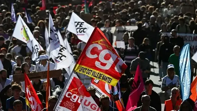 Des manifestants brandissent des drapeaux de la Confédération générale du travail (CGT) et du syndicat CFE-CGC lors d'une manifestation à Nantes, dans l'ouest de la France, le 2 octobre 2025, dans le cadre d'une journée nationale de grève organisée par les huit plus grands syndicats français pour réclamer des mesures de "justice sociale".