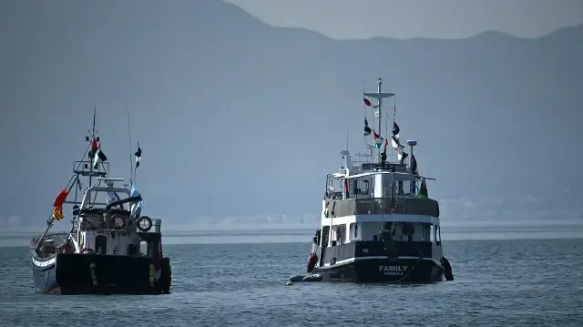 Un navire (à droite), connu sous le nom de Family et faisant partie de la Flottille Global Sumud, est amarré au large du village de Sidi Bou Saïd le 9 septembre 2025.