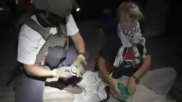 Cette image extraite d’une vidéo diffusée par le ministère israélien des Affaires étrangères le 1er octobre 2025 montre un soldat israélien aux côtés de l’activiste climatique suédoise Greta Thunberg (à droite), après que plusieurs navires de la Flottille Global Sumud “ont été interceptés en toute sécurité et que leurs passagers ont été transférés vers un port israélien.”